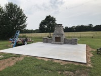 an outdoor fireplace is being built in a field