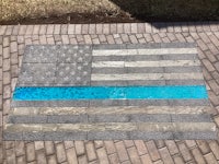a thin blue line flag on a brick walkway